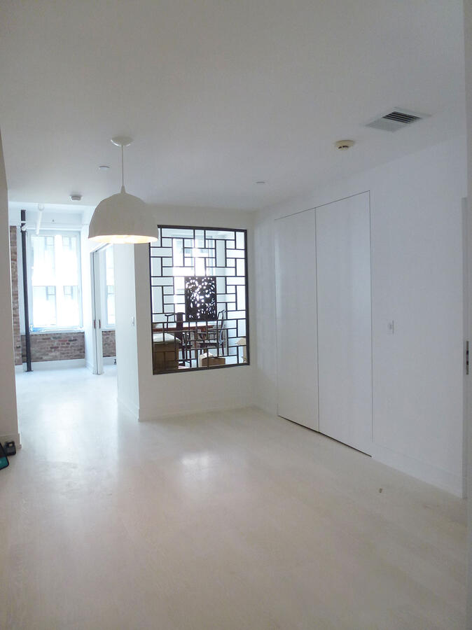 A white room with an Asian patterned separator made of wood