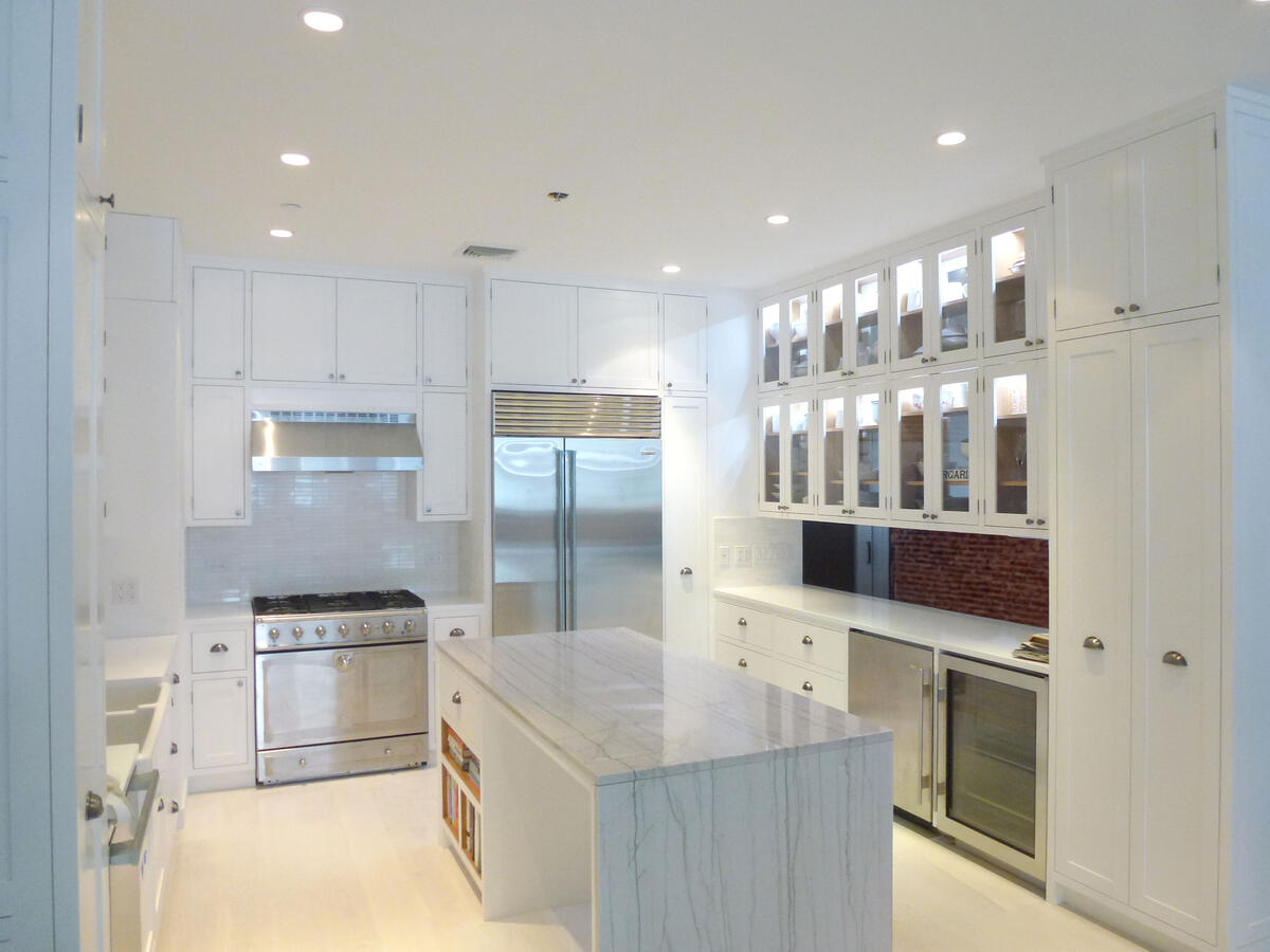 Brightly lit white kitchen with marble counters