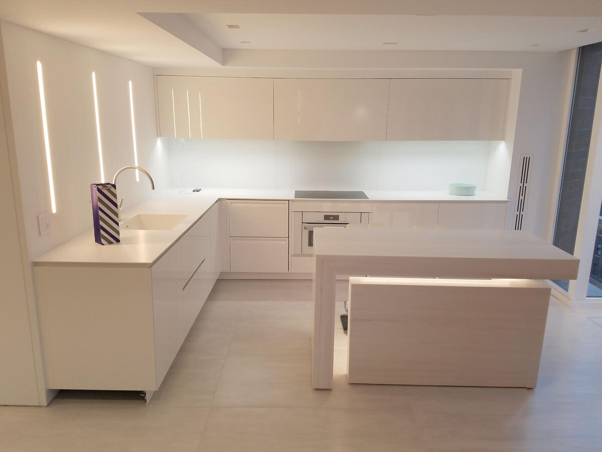 Brightly lit white kitchen with marble counters